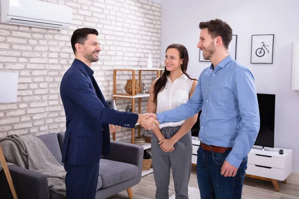 Lächelnder Männlicher Immobilienmakler Beim Händeschütteln Mit Seinen Kunden Neuen Zuhause — Stockfoto
