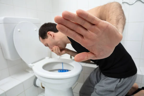 Close Young Man Showing Stop Sign While Vomiting Toilet Bowl — Stock Photo, Image