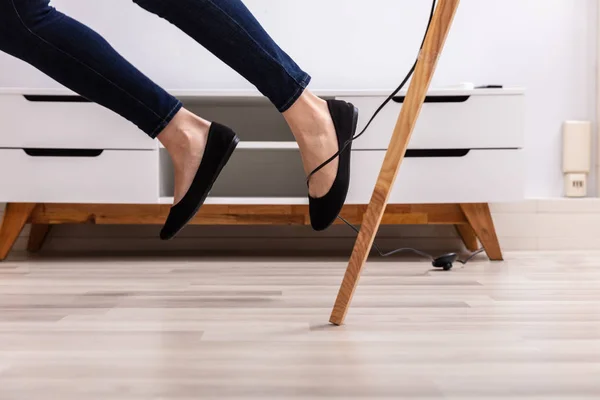 Primer Plano Una Mujer Piernas Tropezando Con Cable Eléctrico Casa —  Fotos de Stock