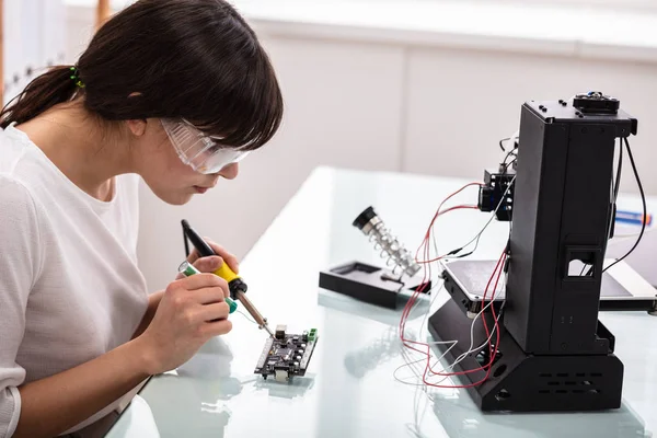 Female Engineer Or Tech Repairs Electronic Device In Hardware Repair Shop