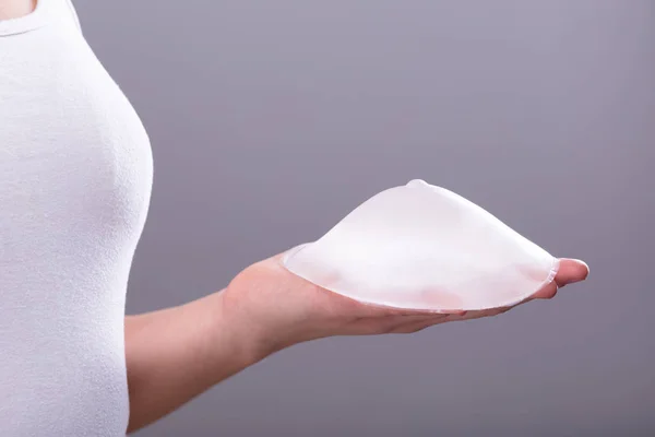 Close Woman Hand Holding Silicon Breast Implant Gray Background — Stok Foto