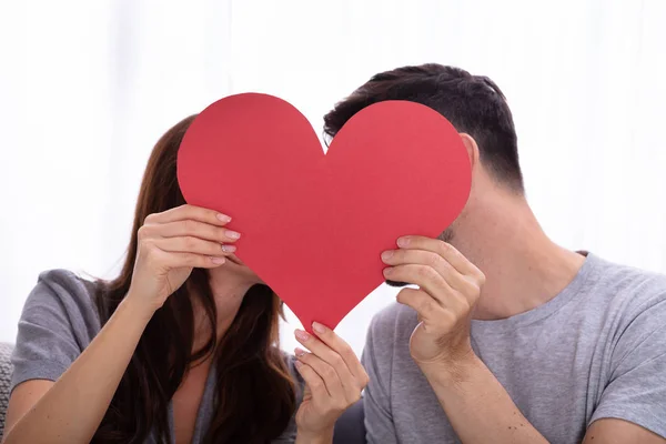 Primer Plano Joven Pareja Escondiéndose Detrás Rojo Forma Corazón — Foto de Stock