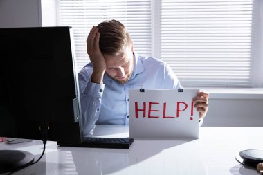 Ofiste Yardım Mesajıyla Karton Tutan Üzgün Genç Adam