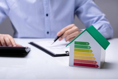 Hesap Makinesi Kullanırken Ofiste Çalışan İşadamları Önü Enerji Verimliliği Oranı Ile Ev