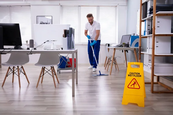 Männlicher Hausmeister Mit Wischmopp Reinigt Modernen Büroboden — Stockfoto