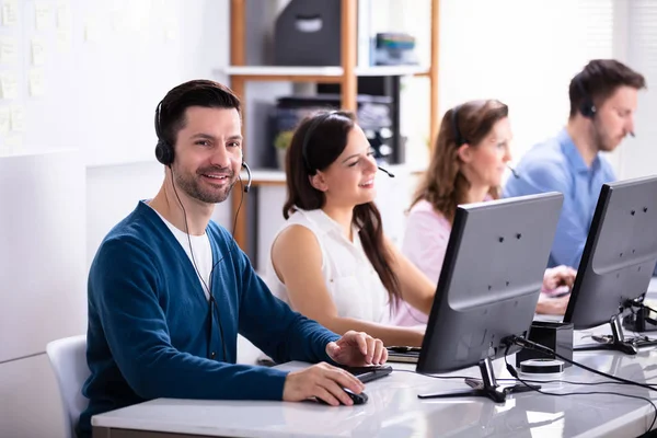 Happy Young Customer Service Executives Met Behulp Van Oortelefoons Werken — Stockfoto