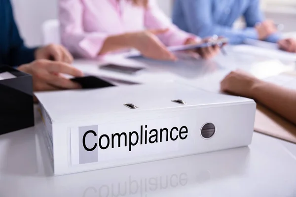 Geschäftsleute Sitzen Der Nähe Von Compliance Dokumenten Über Reflektierendem Schreibtisch — Stockfoto