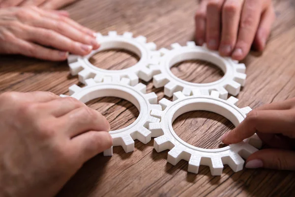 Groep Van Ondernemers Die Samenkomen Versnellingen Houten Tafel Werkplek — Stockfoto