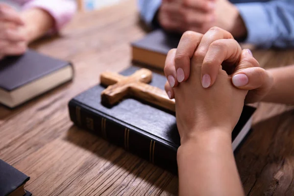 Close Businesspeople Praying Hands Bible Wooden Desk — Stock Photo, Image