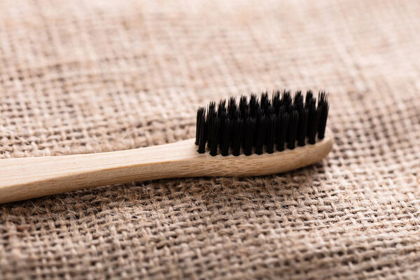 Close-up Of Black Bamboo Toothbrush On Sack Cloth