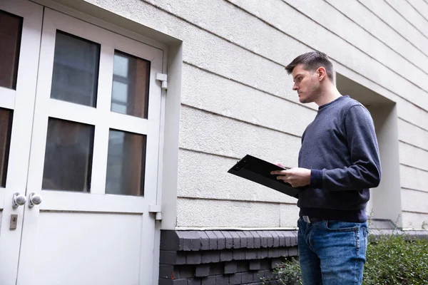 Hombre Servicio Sosteniendo Portapapeles Mano Pie Frente Puerta Cerrada — Foto de Stock