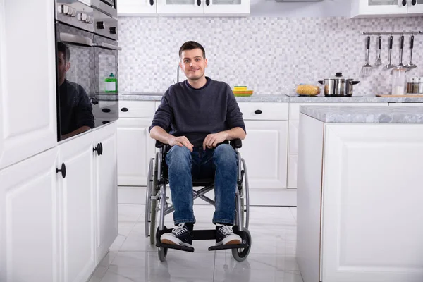 Sorrindo Jovem Deficiente Homem Sentado Cadeira Rodas Cozinha — Fotografia de Stock