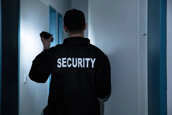 Hátsó Nézet Férfi Biztonsági Zseblámpával Áll Folyosón Épület — Stock Fotó