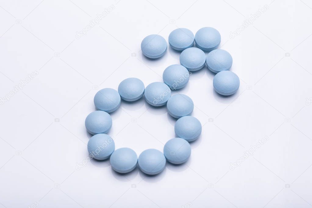 Male Gender Symbol Made From Blue Round Pills On White Background
