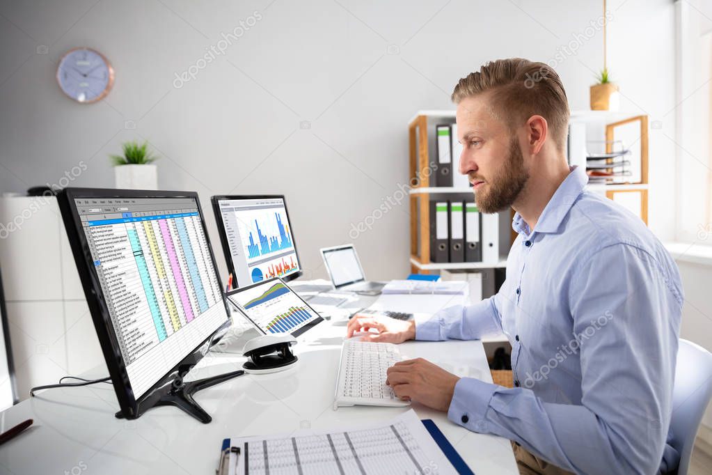 Businessperson Calculating E-Invoice Online On Computer At Office
