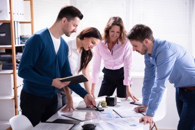 Gülümseyen Genç İş Adamları Grubu Masa Üzerinde Grafik Tartışıyor