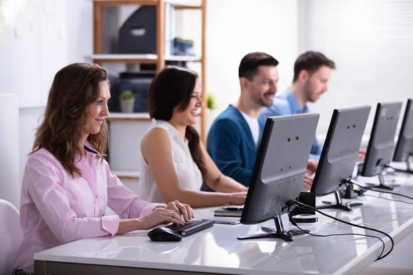 Χαμογελαστοί Νέοι Επιχειρηματίες Που Κάθονται Στη Σειρά Χρησιμοποιώντας Τον Υπολογιστή — Φωτογραφία Αρχείου