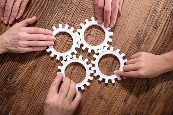 Gruppe Von Geschäftsleuten Die Arbeitsplatz Zahnräder Auf Einem Holztisch Zusammenfügen — Stockfoto