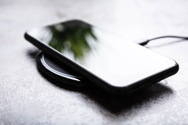 Carregamento Smartphone Uma Almofada Carregamento Sem Fio Sobre Mesa Branca — Fotografia de Stock