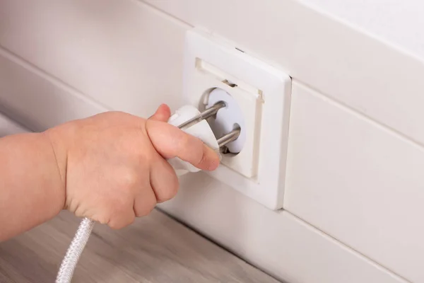 Close Baby Hand Insert Plug Socket — стоковое фото