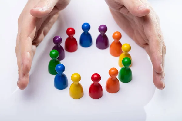 Mão Pessoa Que Protege Multicoloridos Peões Formando Círculo Sobre Mesa — Fotografia de Stock