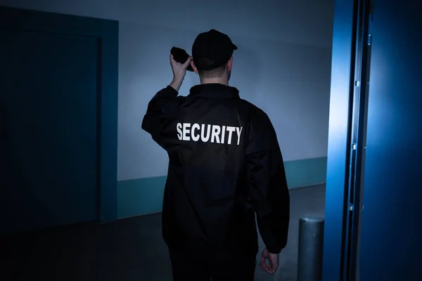 Bakifrån Manlig Säkerhetsvakt Med Ficklampa Stående Korridoren — Stockfoto
