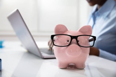 İş yerindeki bir bilgisayarın önünde Pembe Piggy Bank 'ın yakın plan fotoğrafı.