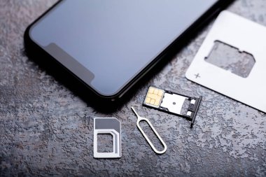 Kart Adaptöründeki Nano Sim Kart Yakınındaki Cep Telefonu Beton Arkaplan Üzerine Pin Atar