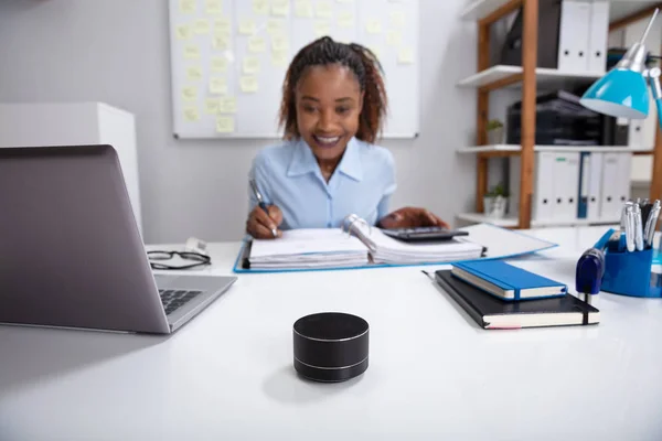 Close-up Of Voice Assistant In Front Of Businesswoman