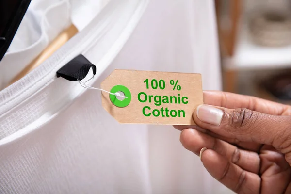 Close Woman Hand Holding Label Showing 100 Percent Organic Cotton — Stock Photo, Image