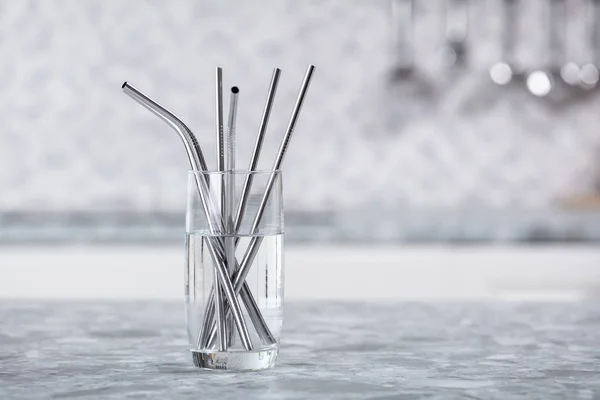 Metal Straws In Transparent Glass Of Water On Kitchen Worktop