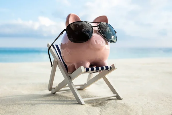 Pink Piggy Bank Bär Solglasögon Hålls Däck Stolen Stranden — Stockfoto