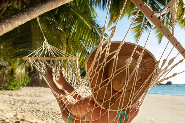 一名穿着比基尼的女子在海滩吊床上戴帽子的特写镜头 — 图库照片