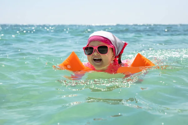 Lachen Meisje Peuter Dragen Zonnebril Opblaasbare Armbandjes Zwemmen Zee — Stockfoto