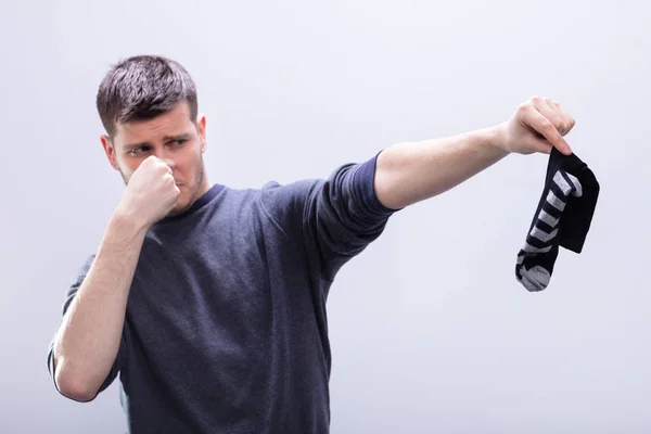 Young Man Holding His Stinking Socks White Background — Stock Photo, Image