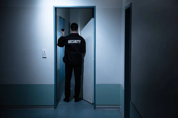 Οπίσθια Όψη Του Ανδρικού Φύλακα Ασφαλείας Φακό Στέκεται Στο Διάδρομο — Φωτογραφία Αρχείου