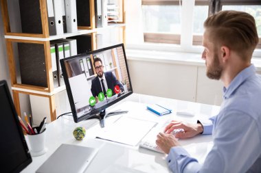 Ofis masasında masaüstü Pc'de iş arkadaşı ile iş adamı video konferans yan görünümü