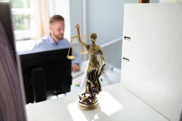 Justice Statue On Shelf And Lawyer Working In Office At background