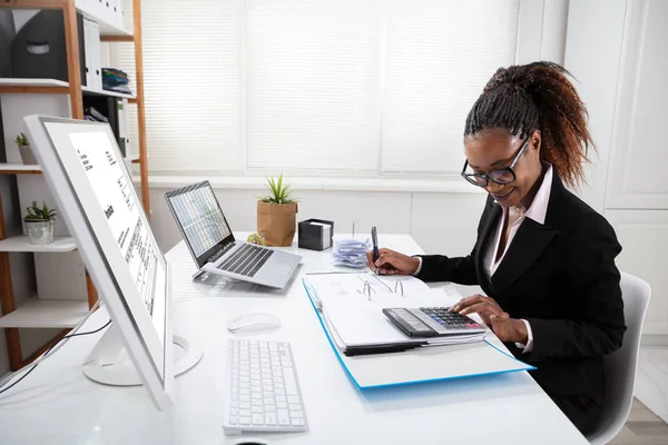 Szczęśliwa Młoda Businesswoman Obliczanie Faktury Ekranie Komputera Pobliżu Laptopa — Zdjęcie stockowe