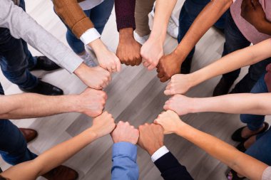 An Overhead View Of Multi-ethnic People's Hand Joining Their Fist To Form Circle clipart