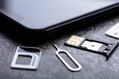 Kart Adaptöründeki Nano Sim Kart Yakınındaki Cep Telefonu Beton Arkaplan Üzerine Pin Atar