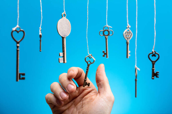 Close-up Of Person's Hand Choosing A Hanging Key Amongst Other Ones