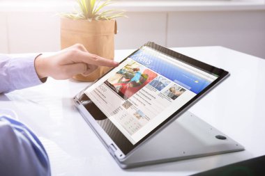 İş adamı el kontrol Online Haberler dizüstü bilgisayar üzerinde Desk