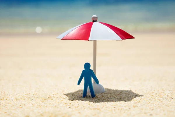 Blízká Modrá Lidská Postava Stojící Pod Červeným Bílým Deštníkem Pláži — Stock fotografie