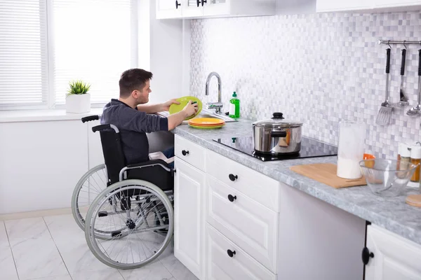 Handicapped Man Sitting Wheelchair Washing Cleaning Dishes Kitchen — Stock Photo, Image