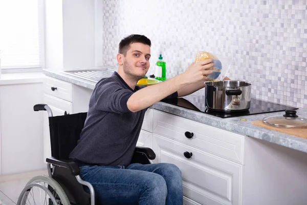 Улыбающийся Молодой Инвалид Сидит Инвалидной Коляске Готовит Еду Кухне — стоковое фото