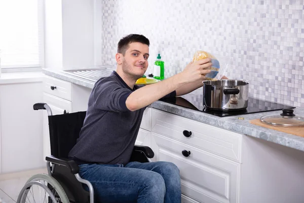 Glimlachende Jonge Gehandicapte Man Zit Rolstoel Het Bereiden Van Voedsel — Stockfoto