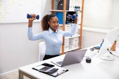 Gülümseyen genç Işkadını mavi dumbbells Ile egzersiz