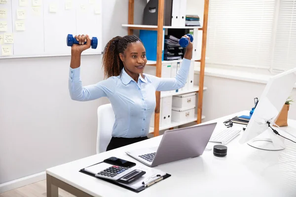 Smiling Young Businesswoman Exercising Blue Dumbbells Dalam Bahasa Inggris — Stok Foto