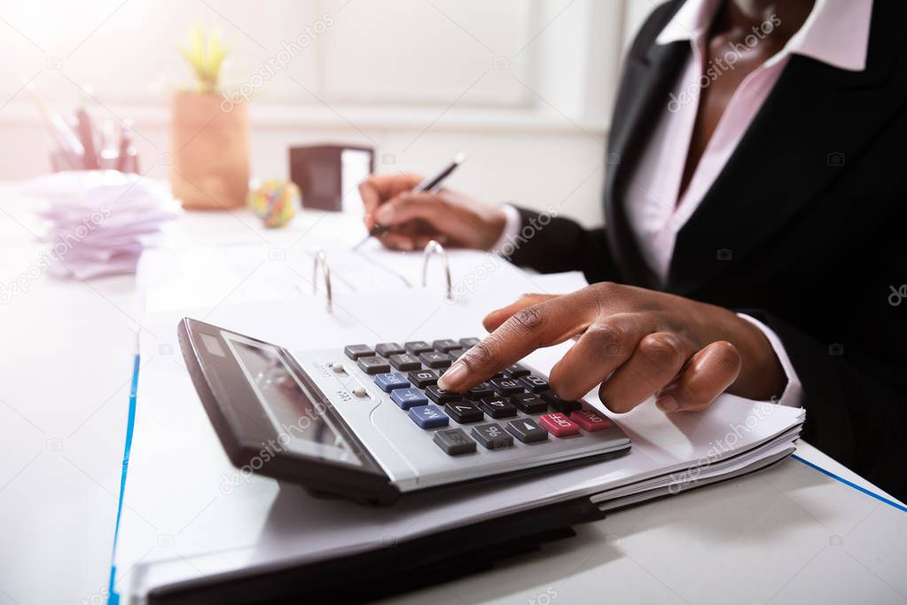 Photo Of Businesswoman's Hand Calculating Bill In Office